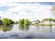 Picturesque lake view featuring mature trees and tranquil water reflecting a partly cloudy sky at 8066 Cardinal Cove E Dr, Indianapolis, IN 46256