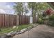 A well-maintained backyard offers privacy with a tall wooden fence and lush green landscaping at 8903 Maple Hill Dr, Indianapolis, IN 46239
