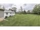 Wide backyard view with a well-maintained lawn, mature trees, and residential building at 8903 Maple Hill Dr, Indianapolis, IN 46239