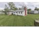 Backyard view of a home with a brick chimney and nice lawn at 8903 Maple Hill Dr, Indianapolis, IN 46239