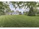 Expansive backyard featuring lush green lawn, mature trees, and a detached garage at 8903 Maple Hill Dr, Indianapolis, IN 46239