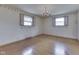 Bedroom with hardwood floors, decorative wallpaper, windows, and a ceiling light fixture at 8903 Maple Hill Dr, Indianapolis, IN 46239