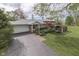 A charming home exterior features manicured landscaping and a long driveway leading to an attached garage at 8903 Maple Hill Dr, Indianapolis, IN 46239