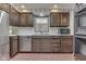 Traditional kitchen featuring stainless steel appliances, dark wood cabinets and brick floors at 8903 Maple Hill Dr, Indianapolis, IN 46239