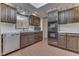Well-lit kitchen featuring brick floors, dark wood cabinets and a dishwasher at 8903 Maple Hill Dr, Indianapolis, IN 46239