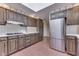 Traditional kitchen featuring stainless steel refrigerator, dark wood cabinets and brick floors at 8903 Maple Hill Dr, Indianapolis, IN 46239