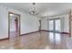Open living room with hardwood floors and view to dining and patio at 8903 Maple Hill Dr, Indianapolis, IN 46239