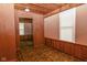 Bedroom featuring wood-paneled walls, linoleum flooring, and a bright window at 8944 W 21St St, Indianapolis, IN 46234