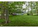 Cozy home featuring a red front porch, set amidst a large grassy yard with shade trees, offering a peaceful setting at 8944 W 21St St, Indianapolis, IN 46234