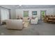 A spacious living room with neutral tones, featuring comfortable seating, a ceiling fan, and a dining area at 8944 W 21St St, Indianapolis, IN 46234
