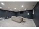 Well-lit finished basement featuring neutral carpet, dark accent walls, and a cozy atmosphere for relaxation or entertainment at 8970 Buttercup Ct, Noblesville, IN 46060