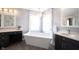 Bright bathroom featuring a soaking tub, gray walls, chandelier, and modern fixtures at 8970 Buttercup Ct, Noblesville, IN 46060