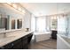 Bright bathroom featuring a soaking tub, gray walls, chandelier, and modern fixtures at 8970 Buttercup Ct, Noblesville, IN 46060