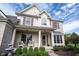 Charming two-story home with a brick facade, a covered front porch, and beautifully landscaped yard with colorful accents at 8970 Buttercup Ct, Noblesville, IN 46060