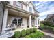 Inviting front porch with seating area, decorative plants, and a beautifully adorned front door, enhancing curb appeal at 8970 Buttercup Ct, Noblesville, IN 46060