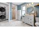 Updated bathroom with white cabinets, modern fixtures, stackable washer/dryer, and tiled shower at 925 S State Ave, Indianapolis, IN 46203
