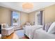 Cozy bedroom featuring two chairs, hardwood floors, neutral walls, and soft natural light at 925 S State Ave, Indianapolis, IN 46203