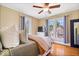 Comfortable bedroom with hardwood floors, a ceiling fan, many windows, and a TV at 925 S State Ave, Indianapolis, IN 46203