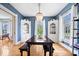 Elegant dining room with built-in hutches, hardwood floors, blue walls, and large windows at 925 S State Ave, Indianapolis, IN 46203