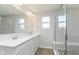 Modern bathroom with dual sinks, a glass-enclosed shower, and sleek white cabinetry at 9767 Behner Dr, Fishers, IN 46250