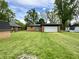 Well-maintained backyard with a brick house, large garage, and lush green grass at 100 Lincoln St, Plainfield, IN 46168