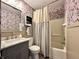 Comfortable bathroom with patterned wallpaper and a neutral striped shower curtain at 100 Lincoln St, Plainfield, IN 46168