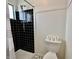 This bathroom features a black tiled shower and a toilet with toilet paper rolls stacked on top at 100 Lincoln St, Plainfield, IN 46168