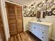 This bathroom has floral wallpaper, wood-look tile, and a white sink at 100 Lincoln St, Plainfield, IN 46168