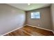 This bedroom features hardwood floors, a neutral wall color, and a window at 100 Lincoln St, Plainfield, IN 46168