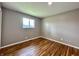 This bedroom features hardwood floors, a neutral wall color, and a window at 100 Lincoln St, Plainfield, IN 46168