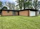 A single-story brick home featuring an attached garage and well-kept lawn at 100 Lincoln St, Plainfield, IN 46168
