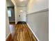 Inviting hallway featuring hardwood floors, wainscoting, and a front door with decorative glass at 100 Lincoln St, Plainfield, IN 46168