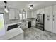 Renovated kitchen featuring white cabinets, stainless steel appliances, and modern lighting fixtures at 100 Lincoln St, Plainfield, IN 46168