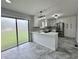 Modern kitchen with white cabinets, stainless steel appliances, island, and sliding glass door at 100 Lincoln St, Plainfield, IN 46168