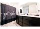 Modern bathroom featuring a double vanity with a white countertop and a humorous 'get naked' shower curtain at 10107 Camp Creek Way, Indianapolis, IN 46229