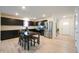 Modern kitchen with stainless steel appliances, dark cabinetry, and a dining table at 10107 Camp Creek Way, Indianapolis, IN 46229