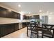 Modern kitchen with stainless steel appliances, dark cabinets, and dining area at 10107 Camp Creek Way, Indianapolis, IN 46229