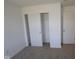 A bright bedroom features neutral carpet, a closet with bi-fold doors, and a classic paneled door at 10126 Redwood Peak Ln, Indianapolis, IN 46259