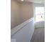 Upstairs hallway filled with natural light from a window, showcasing modern finishes and neutral carpet at 10126 Redwood Peak Ln, Indianapolis, IN 46259