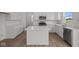 Modern white kitchen features a central island, stainless appliances, and bright lighting at 10126 Redwood Peak Ln, Indianapolis, IN 46259