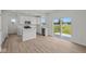 Modern white kitchen has stainless appliances, quartz counters, large window and sliding door at 10126 Redwood Peak Ln, Indianapolis, IN 46259