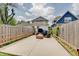 Wide backyard view of patio with outdoor furniture; framed by a wooden fence and mature trees at 1021 Harlan St, Indianapolis, IN 46203
