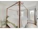 Bright bedroom featuring a four-poster bed, ceiling fan, and natural light from two windows at 1021 Harlan St, Indianapolis, IN 46203