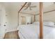 Light and airy bedroom showcasing a four-poster bed, ceiling fan, and sleek wood-look floors at 1021 Harlan St, Indianapolis, IN 46203