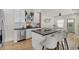 Modern kitchen with white cabinets, dark countertops, and bar stool seating at the island that opens to living area at 1021 Harlan St, Indianapolis, IN 46203