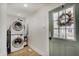 Laundry room features a stacked washer and dryer, and a windowed door at 1021 Harlan St, Indianapolis, IN 46203