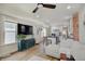 Open-concept living room with hardwood floors, a ceiling fan, and a large TV for entertainment and relaxation at 1021 Harlan St, Indianapolis, IN 46203