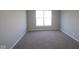 Cozy carpeted bedroom with neutral gray walls and bright, sunlit window at 10544 Maidenhair Dr, Indianapolis, IN 46239