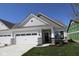 Charming home featuring a two-car garage with stone accents and classic carriage doors at 10544 Maidenhair Dr, Indianapolis, IN 46239