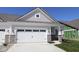 Charming home featuring a two-car garage with stone accents and classic carriage doors at 10544 Maidenhair Dr, Indianapolis, IN 46239